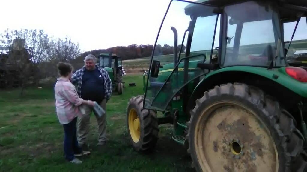 A grandfather and grandaughter near a big tractor